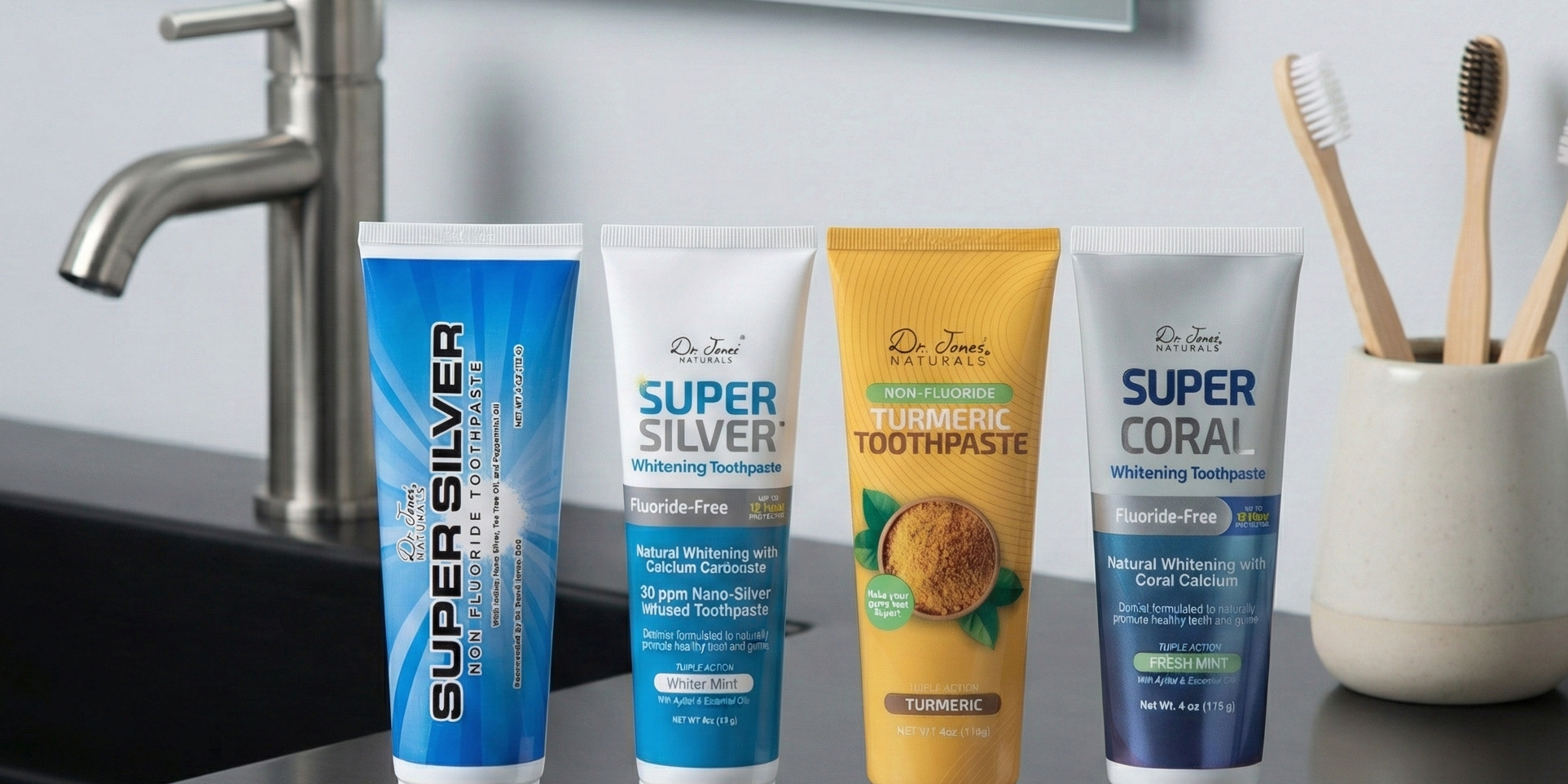 Four tubes of Super Silver and Super Coral toothpaste on a bathroom counter with a mirror and toothbrush holder in the background.
