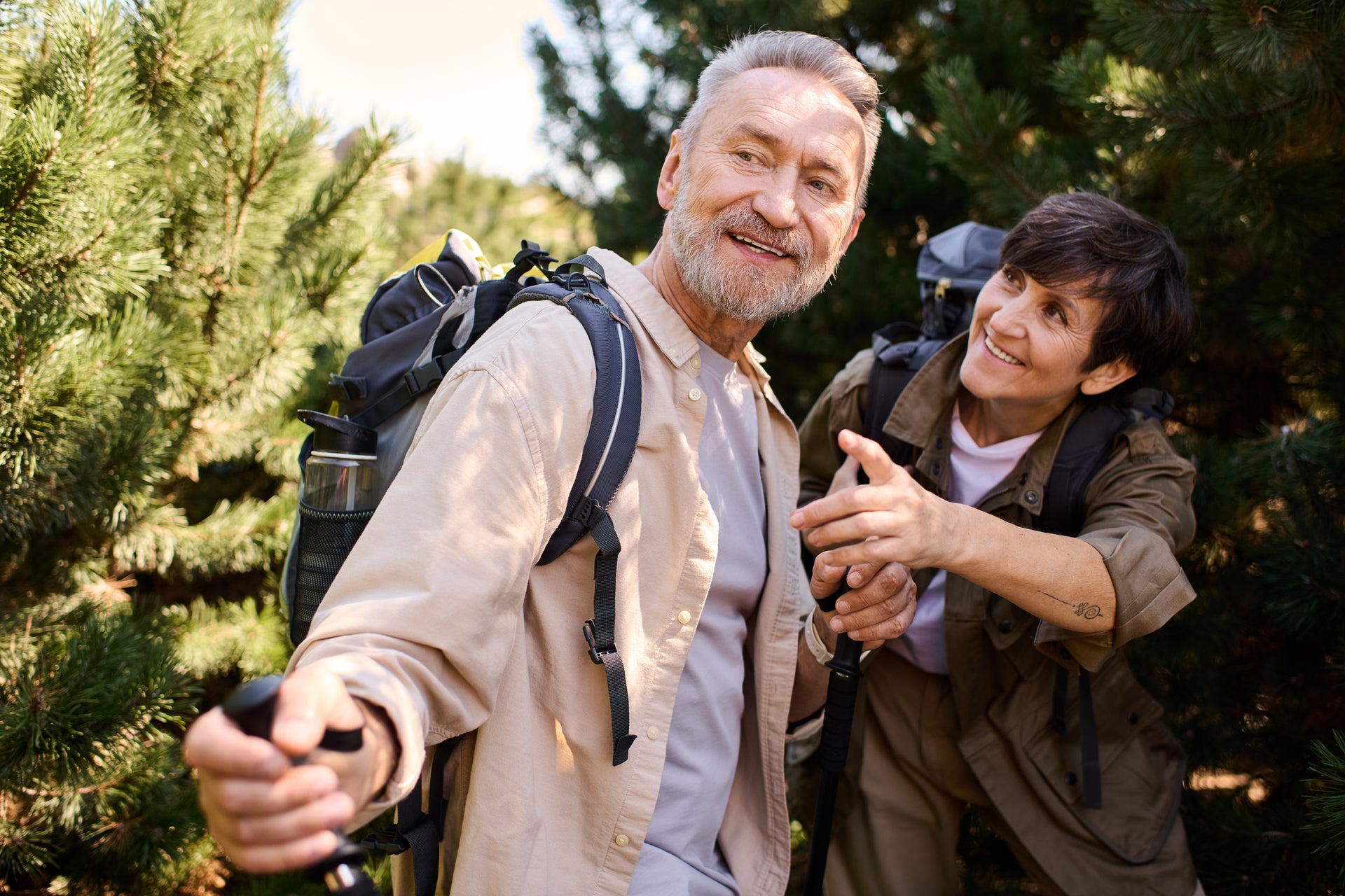 Two people hiking in a forest, one of them is taking a selfie. Golden Vitality